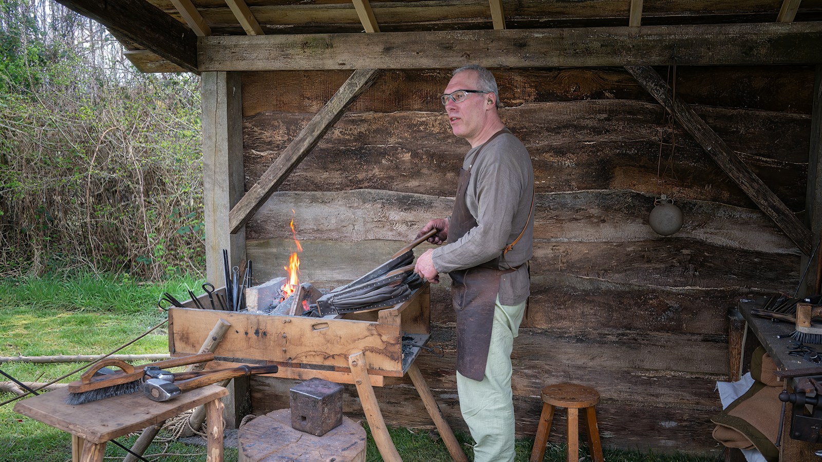 Illustrative stock photo: a blacksmith working at a forge with flames