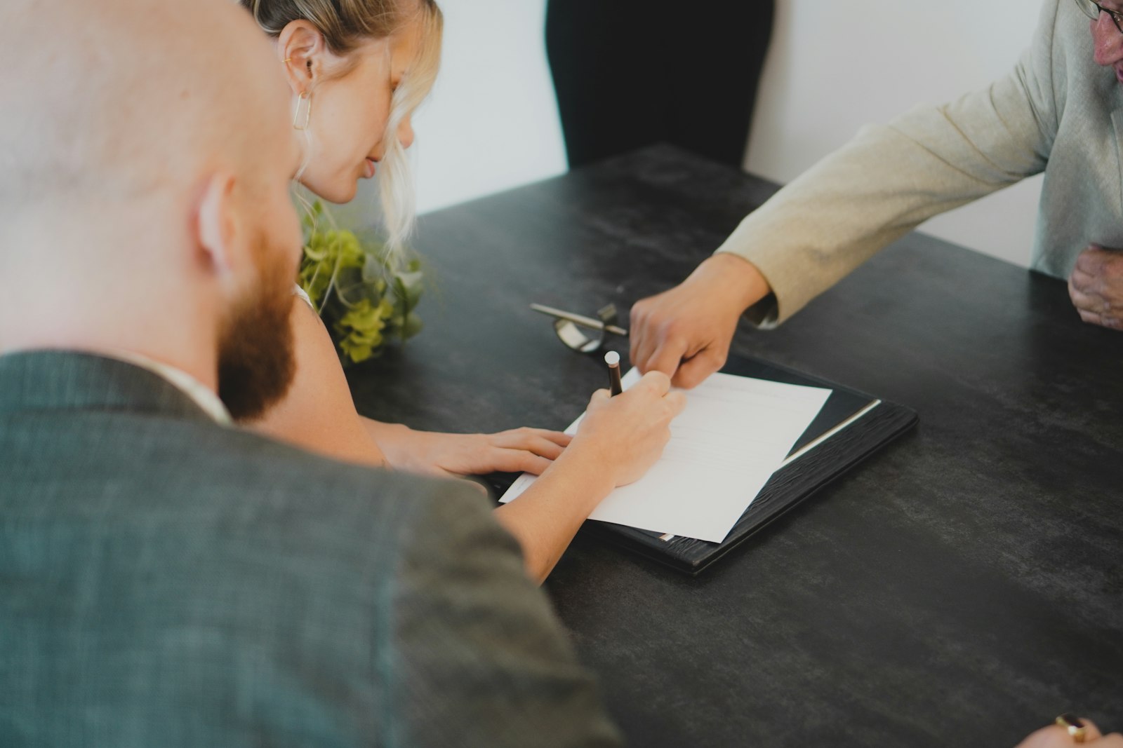 Two people signing a document at a desk, representing a startup formalizing a working relationship