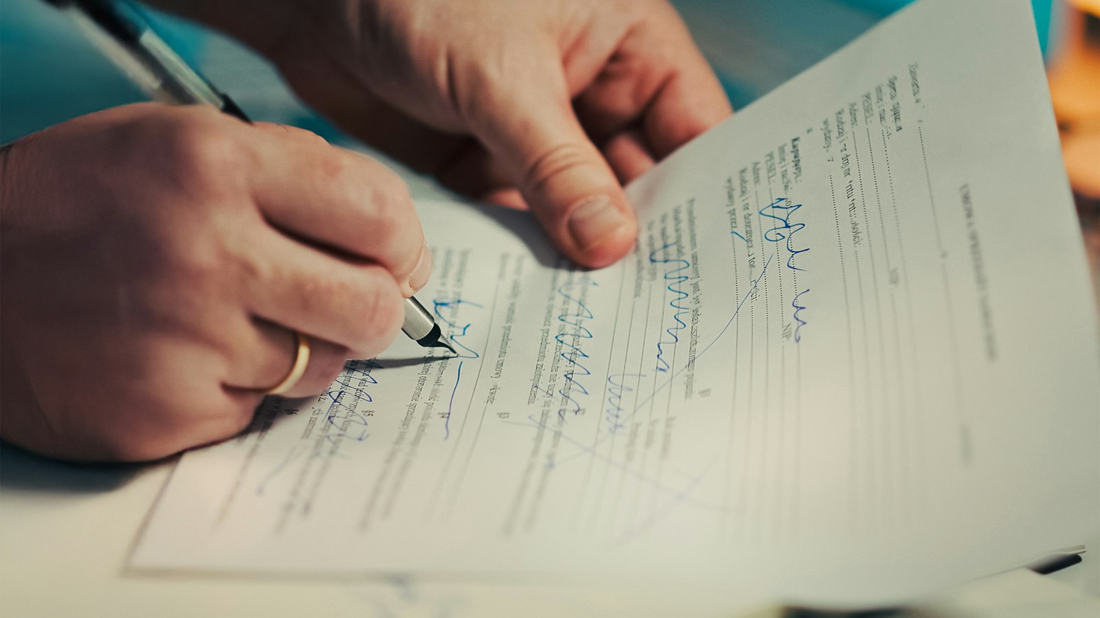 A man signing a document with a pen