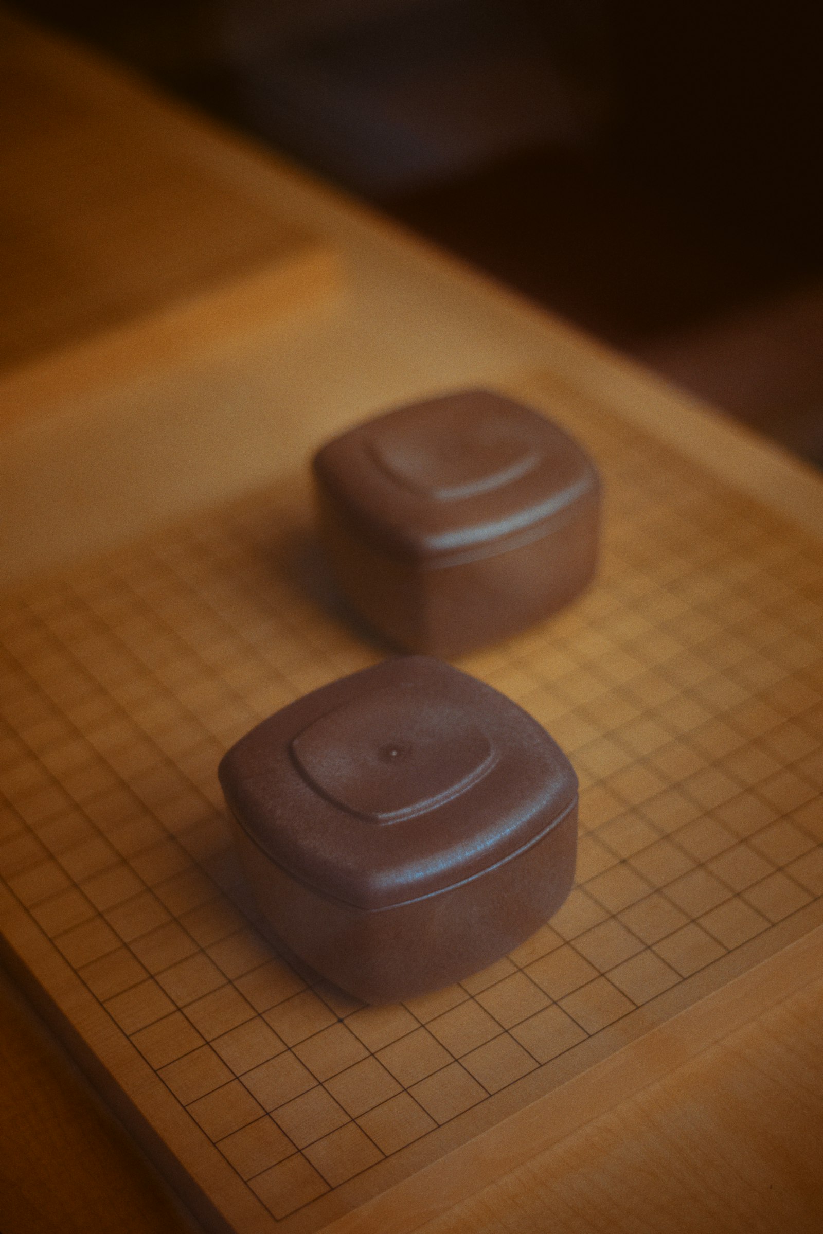 Two stone bowls sit on a go board