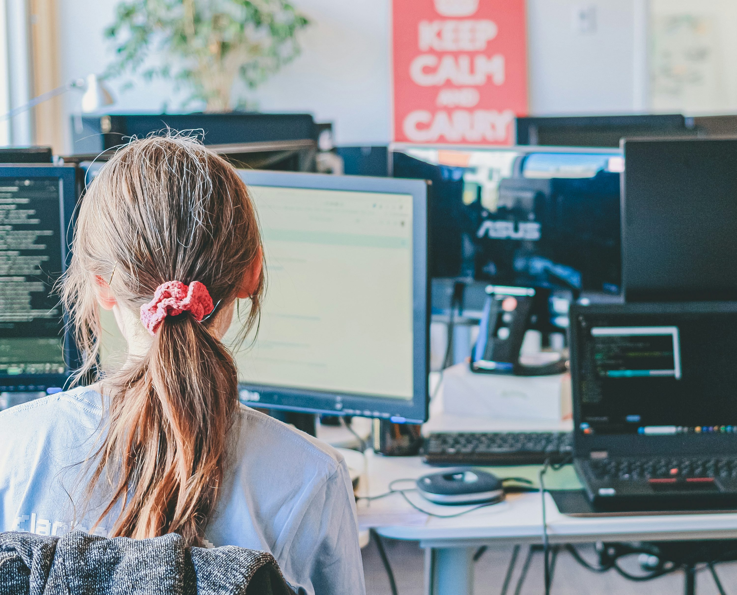 A developer working at a desk with multiple screens.